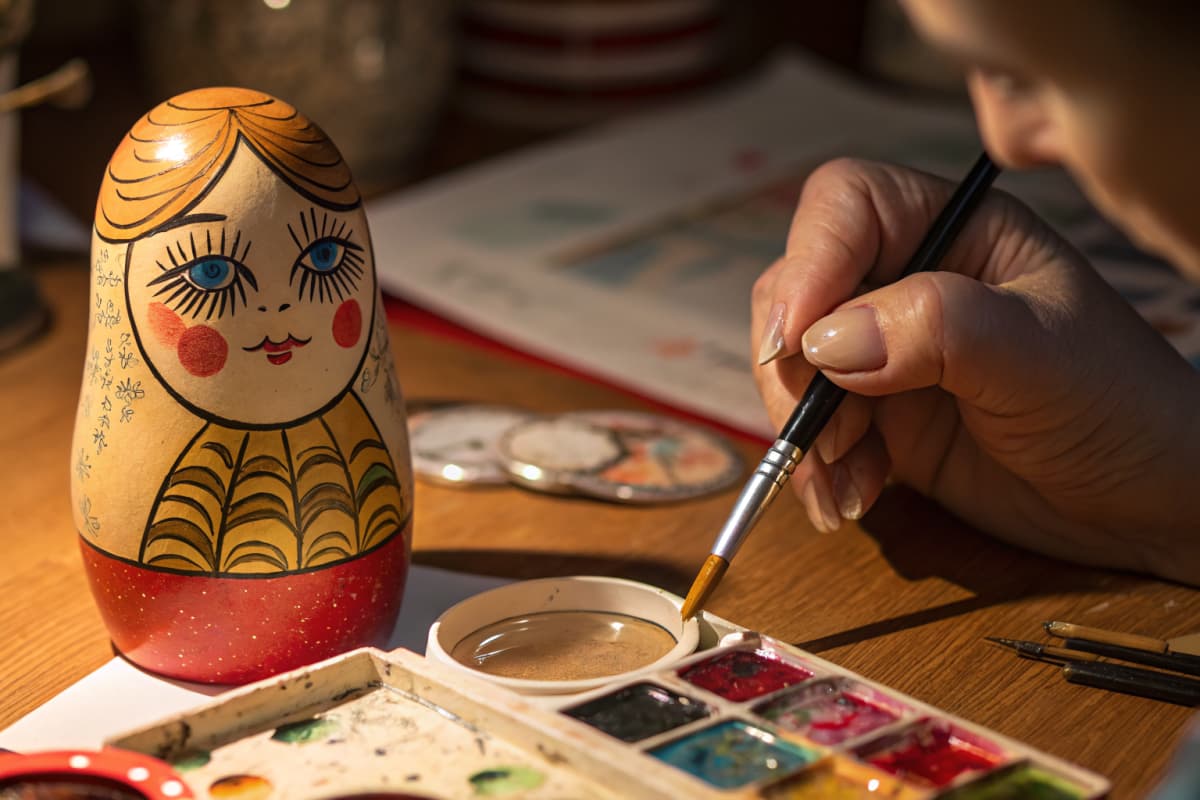 Close-up detail of hand-painting a nesting doll